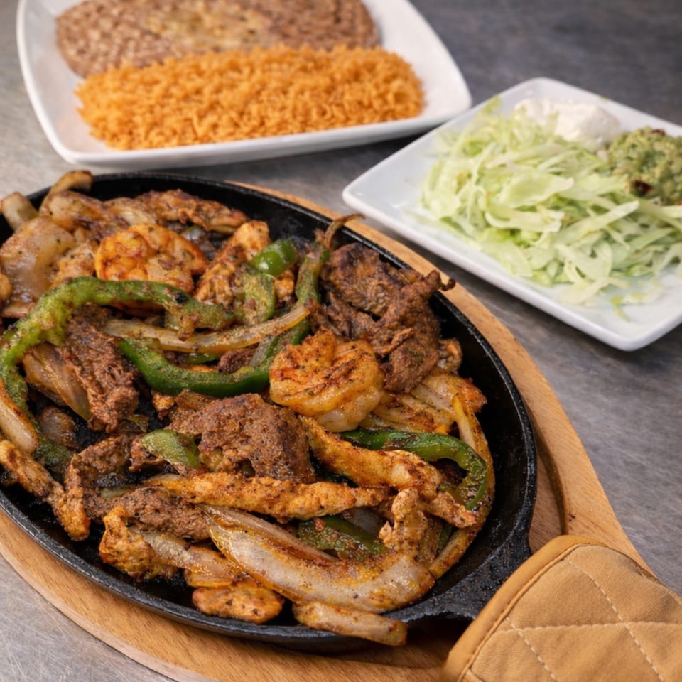 Sizzling fajitas with chicken, steak, shrimp, peppers, and onions, served with rice, beans, and salad.