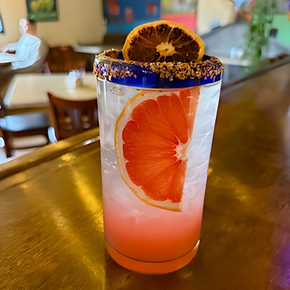 A La Esperanza Mexican restaurant cocktail with grapefruit, dried orange, and a chili-lime rim.
